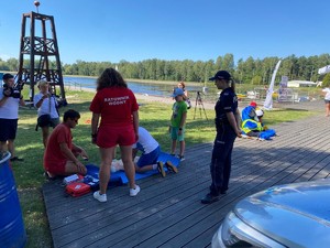 ..ratowniczka WOPR obserwująca ucisnięcie  fantoma obok stoi umundurowana policjantka