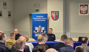 Na zdjęciu widoczna na pierwszym planie publiczność w postaci funkcjonariuszy KPP Chrzanów i zaproszeni goście, przy stole po środku siedzi Komendant Wojewódzki Policji w Krakowie nadinsp. Artur Bednarek, przy stole po lewej siedzi p.o. 1-szy Zastępca Komendanta Powiatowego Policji w Chrzanowie podinsp. Rafał Kaczmarczyk.