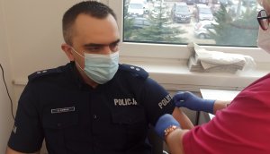 Policjant w mundurze szczepiony w szpitalu w Chrzanowie