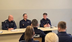 Od lewej mł. insp. Mirosław Kotulski - Komendant Komisariatu Policji w Trzebini, podinsp. Adrian Loręs - Zastępca Komendanta Komisariatu Policji w Trzebini, podinsp. Zbigniew Zacher - Komendant Powiatowy Policji w Chrzanowie, na pierwszym planie widoczni funkcjonariusze Policji siedzący na widowni.
