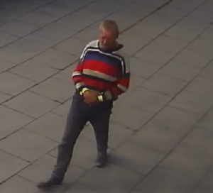 Mężczyzna idący po chodniku.