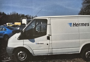 Pojazd dostawczy zaparkowany na parkingu firmy pomocy drogowej.