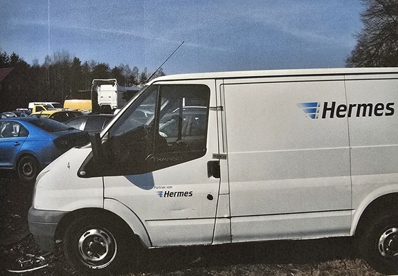 Pojazd dostawczy zaparkowany na parkingu firmy pomocy drogowej.