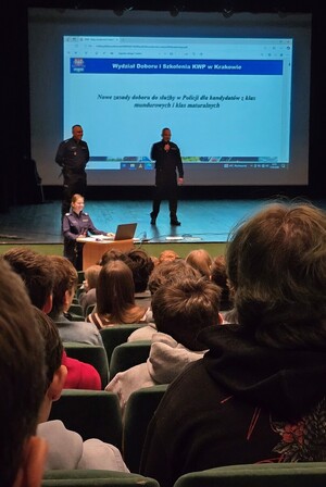 Na zdjęciu na tle głów młodzieży widoczny I Zastępca Komendanta KPP Chrzanów podinsp. Grzegorz Żmudka, a po jego lewej Naczelnik Wydziały Prewencji KPP Chrzanów, nadkom. Grzegorz Cupiał.