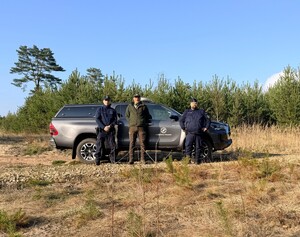 Na zdjęciu widoczny pojazd służbowy Straży Leśnej w Chrzanowie, przed pojazdem stoi Funkcjonariusz Straży Leśnej oraz Dzielnicowi KPP Chrzanów.
