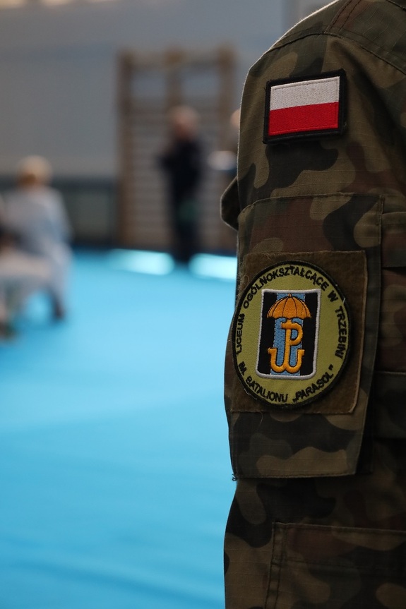 Ramię ucznia klasy mundurowej, naszywka szkoły i naszywka flaga Polski.