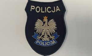 Na zdjęciu widoczna jest naszywka z białym orłem w koronie oraz napisem Policja