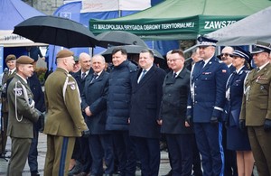 funkcjonariusze służby wojskowej, Policji ubrani w mundur wyjściowy stoją w rzędzie. Wita ich przedstawiciel służby wojskowej